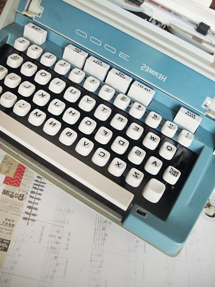 computer hardware white and teal Hermes 3000 typewriter on white paper computer keyboard